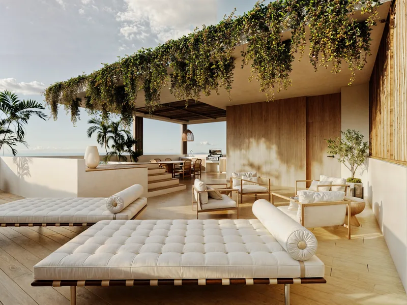 Shaded lounge terrace with daybeds under hanging greenery, facing the ocean