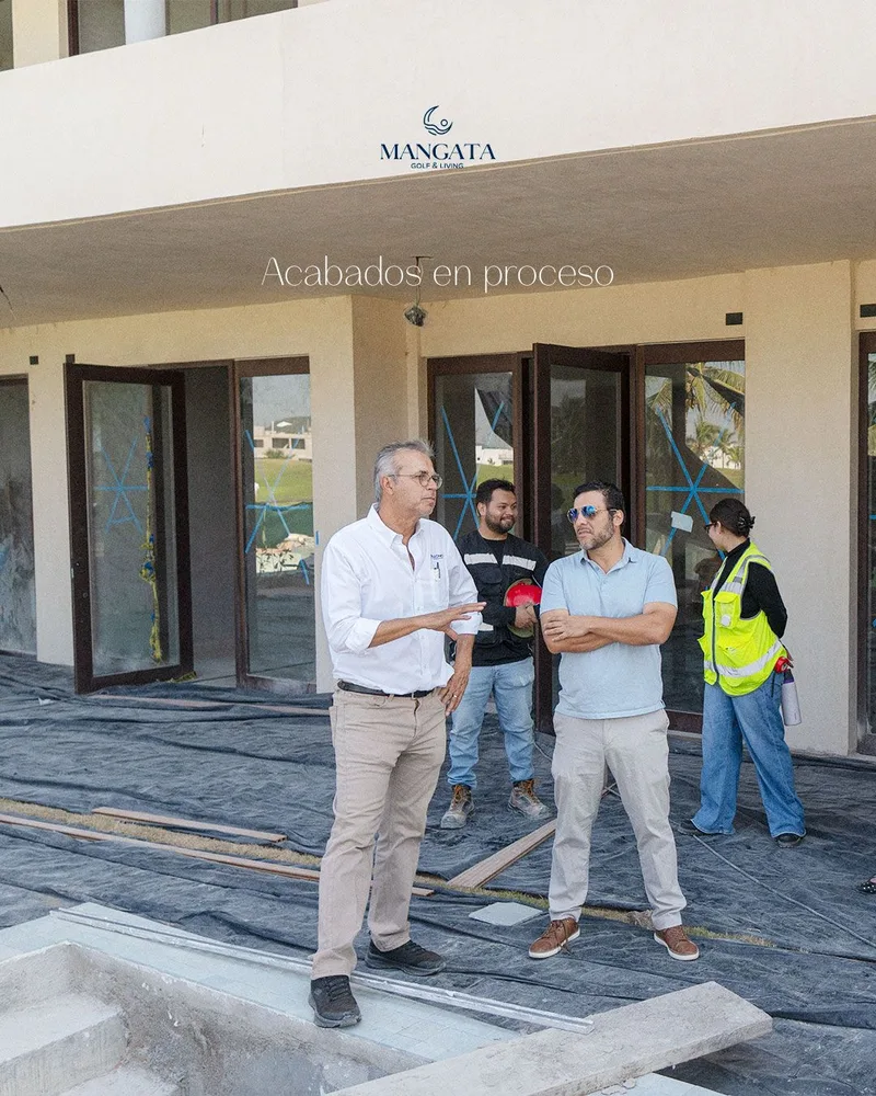 Recorrido de obra con personal y visitantes frente al edificio, bajo el rotulo «Acabados en proceso»