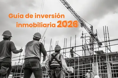 Trabajadores de la construccion con casco frente a una grua, bajo el titulo «Guia de inversion inmobiliaria 2026»