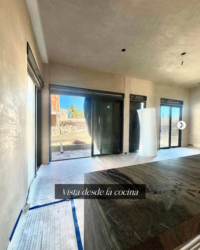 Vista desde la cocina hacia los ventanales de la terraza, con el departamento en obra