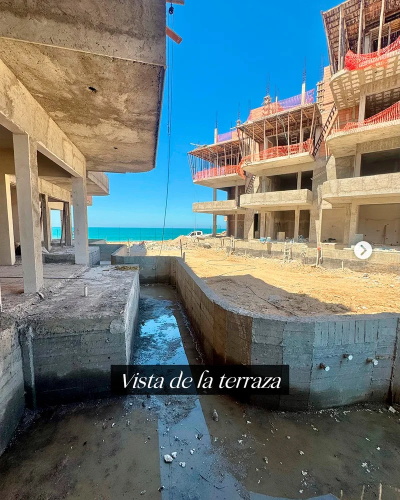 Vista desde la terraza hacia el mar, con la estructura del edificio en obra