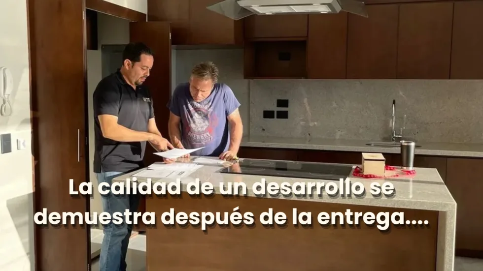 Dos personas revisando documentos en la cocina, con la frase «La calidad de un desarrollo se demuestra despues de la entrega»