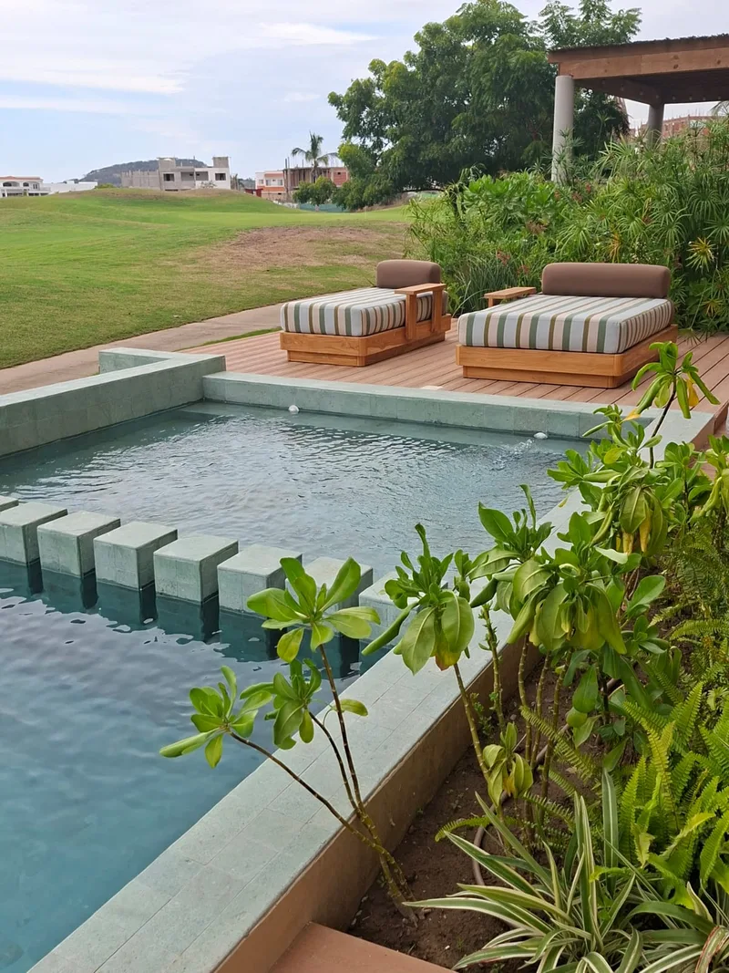 Alberca privada con camastros y vegetacion, frente al campo de golf