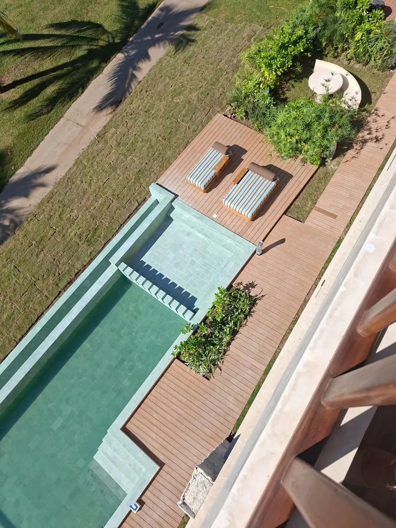 Vista cenital de la alberca y la terraza de madera de la villa