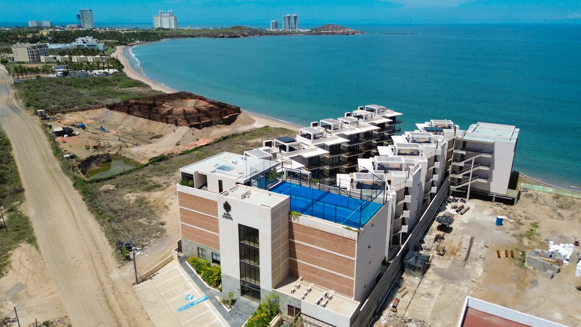 Vista aérea de la costa de Mazatlán con la ciudad y sus torres al fondo
