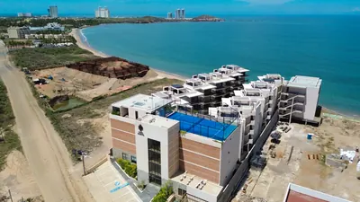Vista aérea de la costa de Mazatlán con la ciudad y sus torres al fondo
