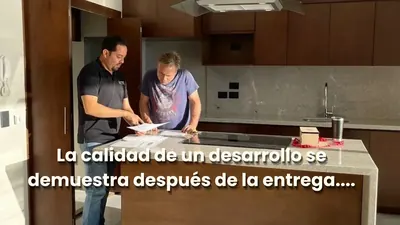 Asesor inmobiliario y cliente revisando el papeleo dentro de un departamento en Mazatlán, durante la entrega oficial, representando el servicio de posventa y las garantías de departamentos nuevos.